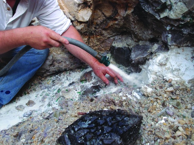 River of Gems being hosed down, while clay melting away, reveals crystals.